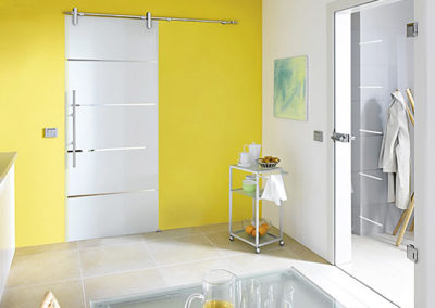 Modernes Schiebetürsystem mit Glas und gelber Wand in einem Wohnraum
