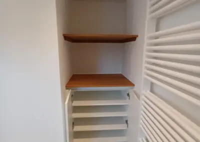 Maßgefertigter Nischenschrank im Badezimmer mit weißen Türen und geölter Eichenplatte, gefertigt von Tischler Daniel Albani aus Korschenbroich